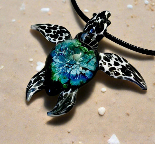 glass black and white spotted sea turtle pendant with iceberg style explosion in the shell at a 60 degree angle.